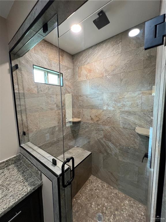 bathroom with a shower stall and vanity