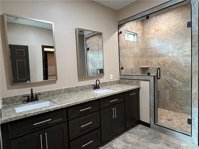bathroom with double vanity, a sink, and a stall shower