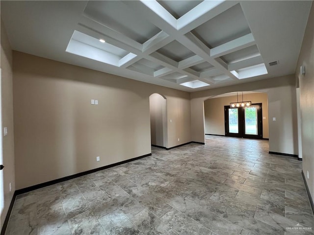empty room with visible vents, arched walkways, baseboards, beamed ceiling, and coffered ceiling