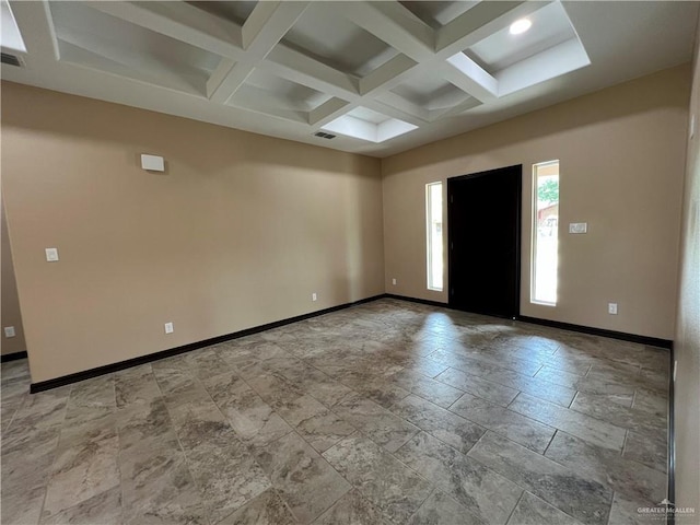 spare room with stone finish floor, visible vents, baseboards, beamed ceiling, and coffered ceiling
