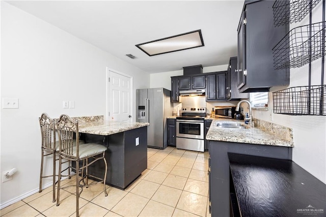 2103 Obra Dorado Rd, Mission, TX 78572 - kitchen featuring appliances with stainless steel finishes, under cabinet range hood, a peninsula, and light stone counters