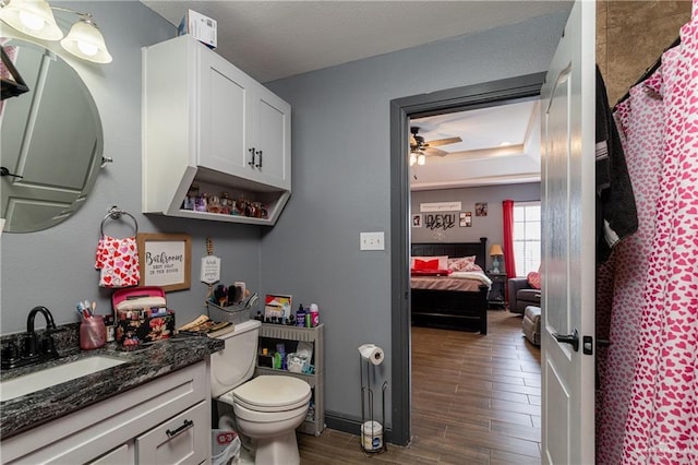 bathroom with hardwood / wood-style floors, toilet, ceiling fan, and vanity