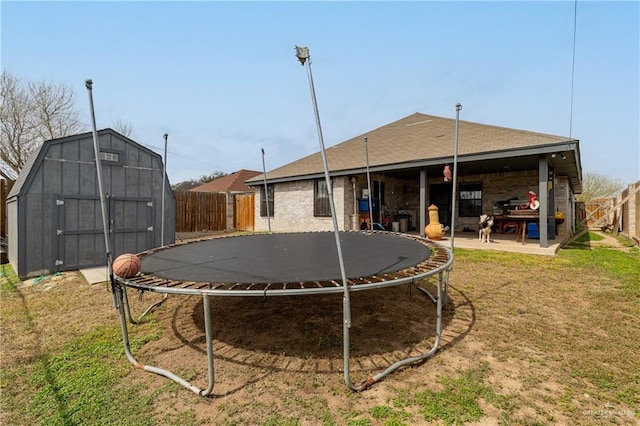 view of yard with a trampoline, a shed, and a patio area