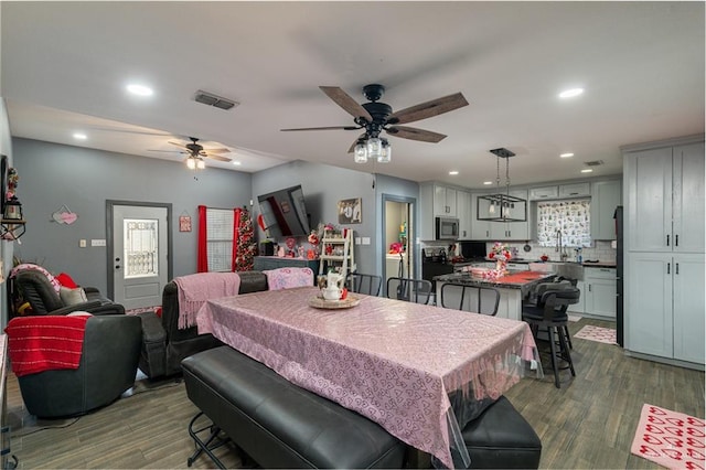 dining space with ceiling fan and dark hardwood / wood-style floors