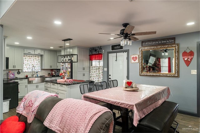 dining space featuring ceiling fan, sink, and dark hardwood / wood-style floors