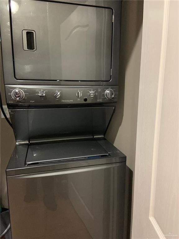 clothes washing area featuring stacked washing maching and dryer