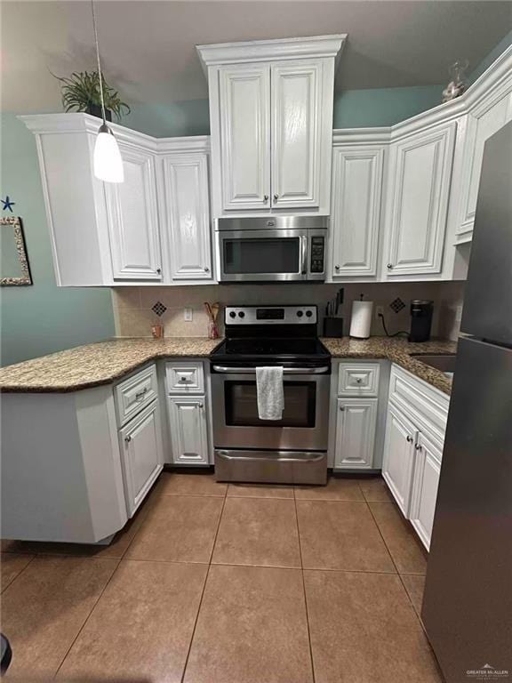 kitchen featuring white cabinetry, stainless steel appliances, decorative light fixtures, and tile patterned flooring