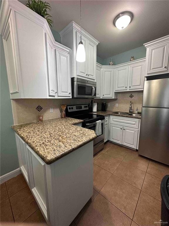 kitchen with stainless steel appliances, sink, pendant lighting, and white cabinets