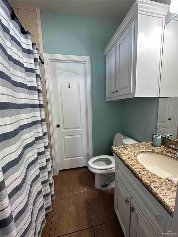 bathroom with tile patterned flooring, vanity, and toilet