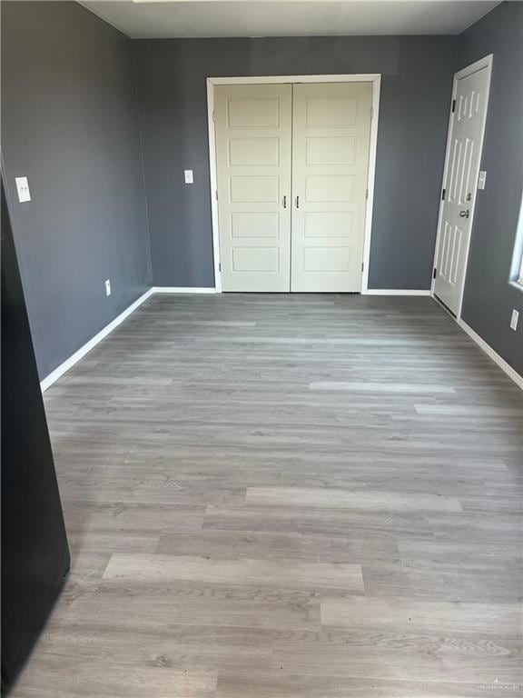 121 N Kentucky St, Mission, TX 78573 - unfurnished bedroom with baseboards, wood finished floors, and a closet