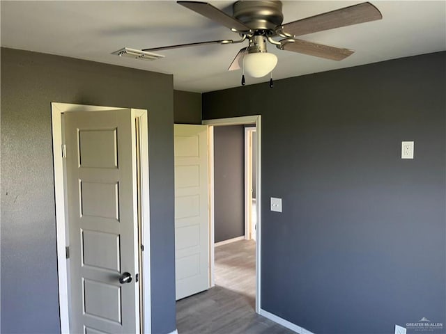 121 N Kentucky St, Mission, TX 78573 - unfurnished bedroom featuring dark wood-type flooring, baseboards, and a ceiling fan