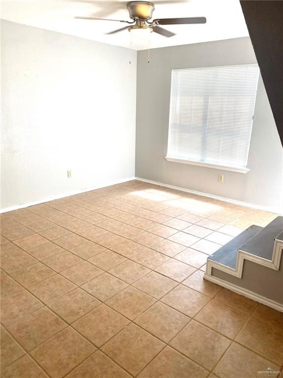 empty room featuring light tile patterned floors and ceiling fan