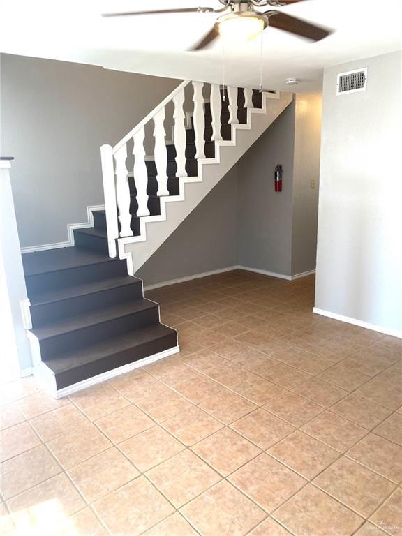 staircase with tile patterned flooring and ceiling fan