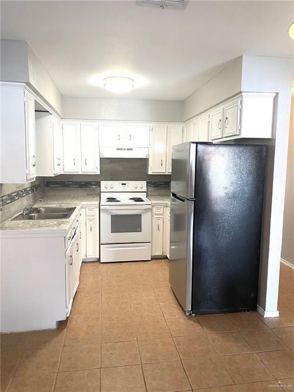 kitchen with stainless steel refrigerator, white range with electric stovetop, white cabinetry, sink, and backsplash