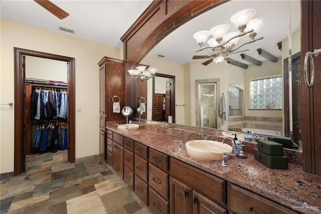 bathroom featuring vanity, a bath, and ceiling fan with notable chandelier