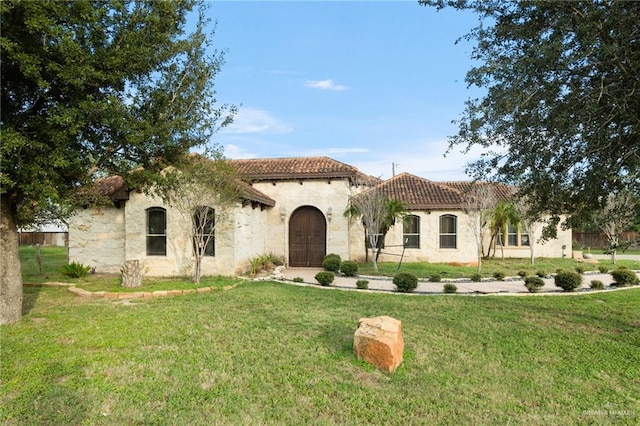 mediterranean / spanish house featuring a front lawn