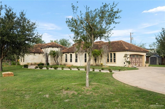 mediterranean / spanish house featuring a garage and a front lawn