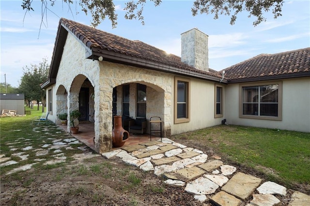 back of house with a patio area and a lawn