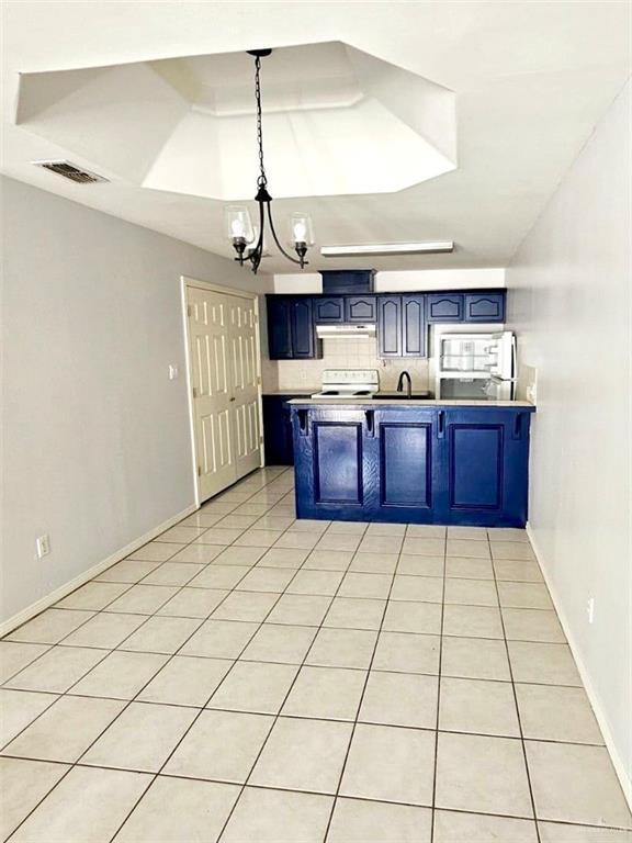 1417 Prosperity Dr, Edinburg, TX 78541 - kitchen featuring under cabinet range hood, blue cabinets, a peninsula, stove, and visible vents