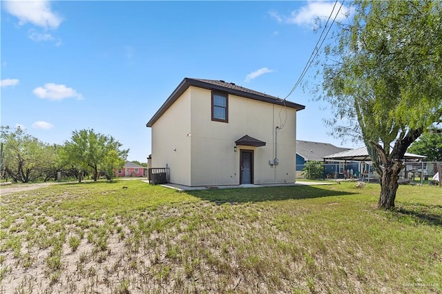 rear view of property featuring a lawn