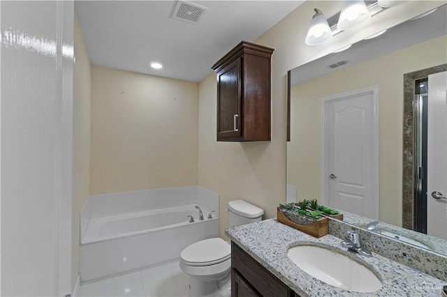 bathroom with tile patterned floors, a washtub, vanity, and toilet