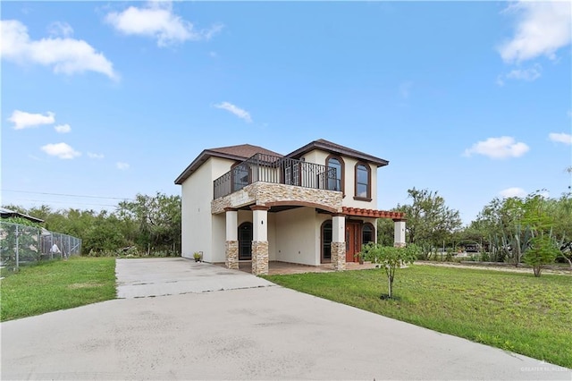 view of front of house with a balcony and a front yard