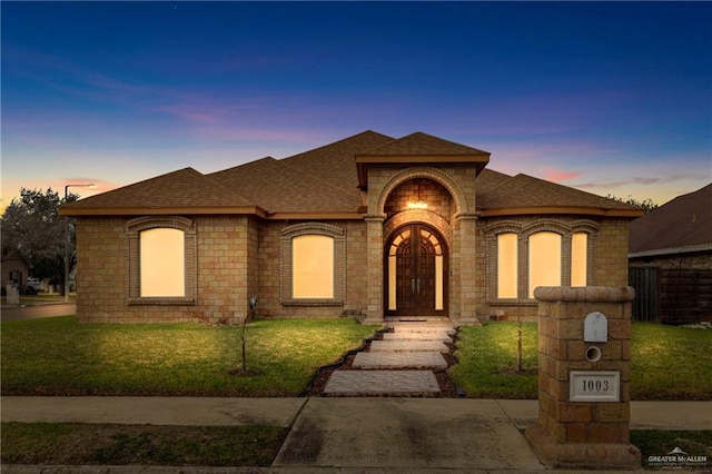 view of front of property featuring french doors and a yard