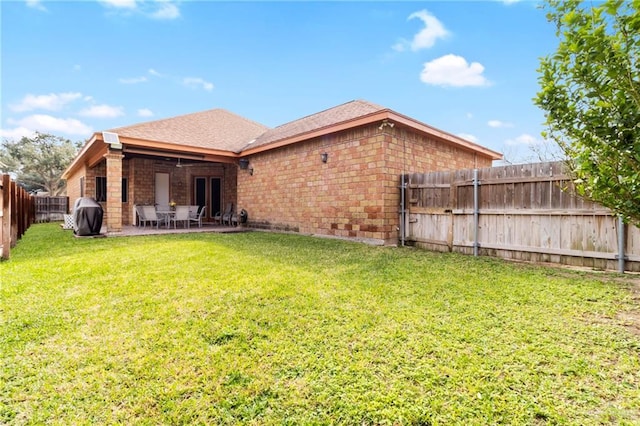 back of property featuring a lawn and a patio