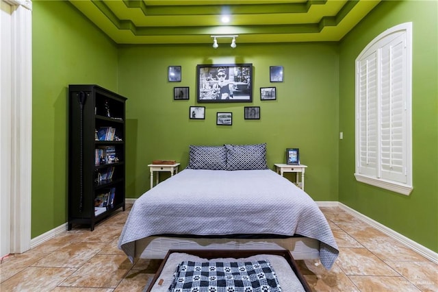 bedroom featuring a raised ceiling and light tile patterned floors