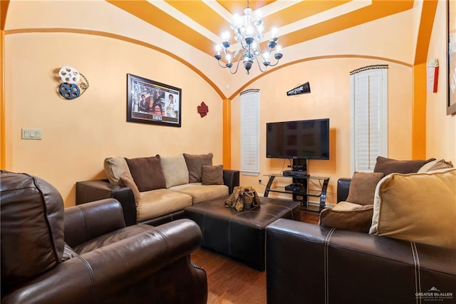 living room with hardwood / wood-style flooring, a raised ceiling, and a chandelier