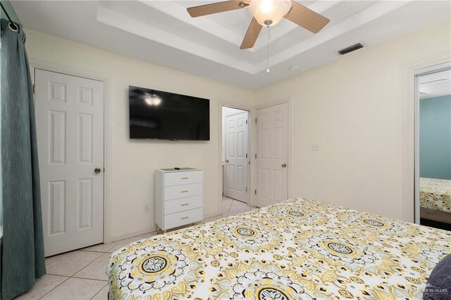 103 W Dolphin St Unit 1B, South Padre Island, TX 78597 - bedroom with light tile patterned floors, a raised ceiling, visible vents, and a ceiling fan