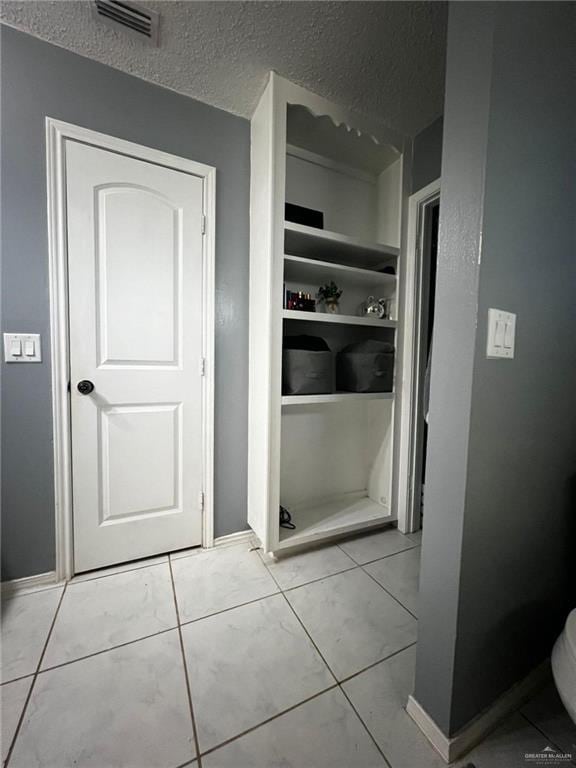 bathroom featuring a textured ceiling, visible vents, and baseboards
