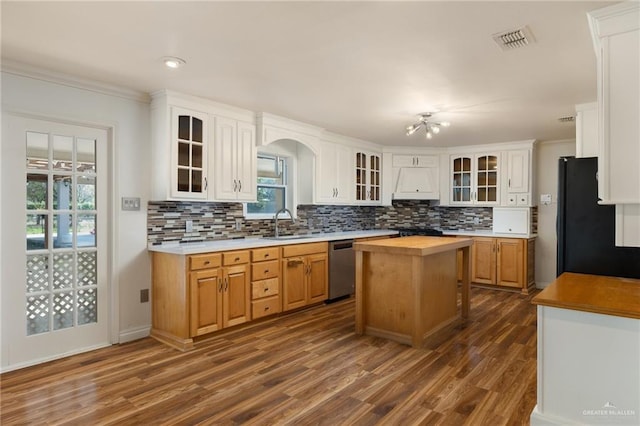 kitchen with stainless steel dishwasher, a center island, black fridge, and white cabinets