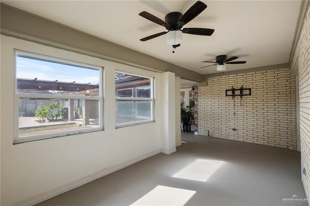 unfurnished sunroom with ceiling fan