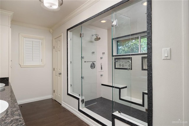 bathroom featuring hardwood / wood-style floors, vanity, ornamental molding, and walk in shower