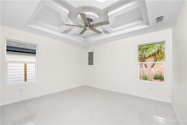 tiled empty room featuring a tray ceiling, electric panel, ceiling fan, and coffered ceiling