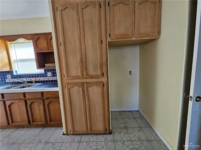 kitchen with tile counters, sink, decorative backsplash, and light tile patterned floors