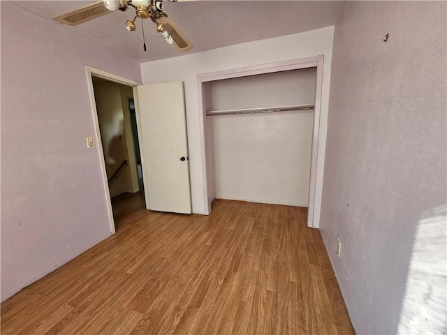 unfurnished bedroom with ceiling fan, a closet, and light hardwood / wood-style flooring