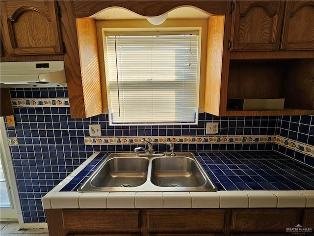 kitchen featuring tasteful backsplash, tile countertops, sink, and a wealth of natural light