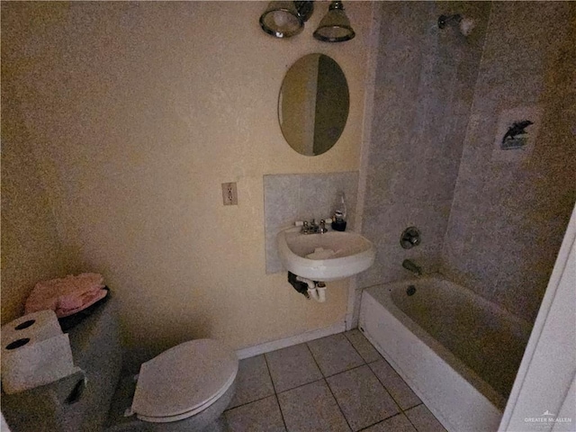 bathroom featuring tile patterned flooring, a bathing tub, sink, and toilet