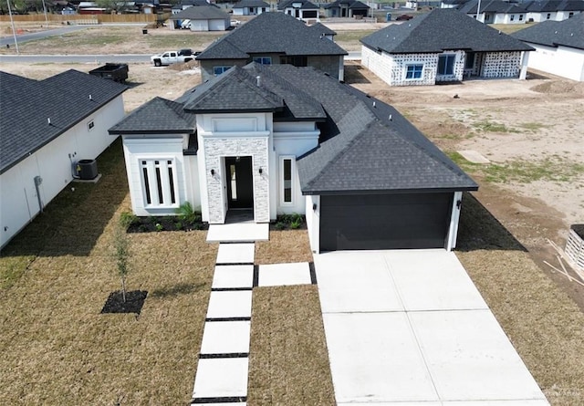 view of front of property featuring central AC and a garage