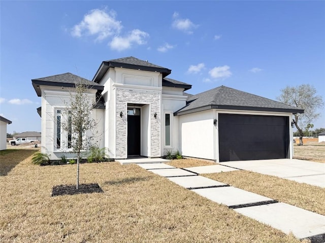 prairie-style home featuring a garage and a front lawn