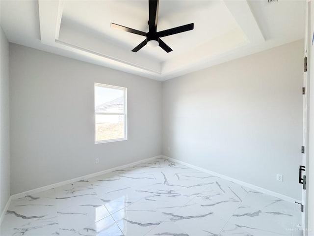 spare room featuring ceiling fan and a tray ceiling