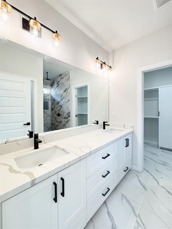 bathroom with vanity and tiled shower