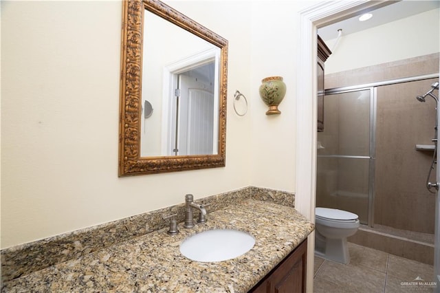full bath with a shower stall, vanity, tile patterned flooring, and toilet