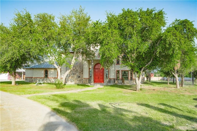 obstructed view of property with a front lawn and stucco siding