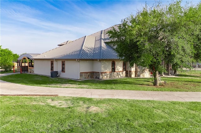 view of property exterior with stucco siding, stone siding, and a lawn
