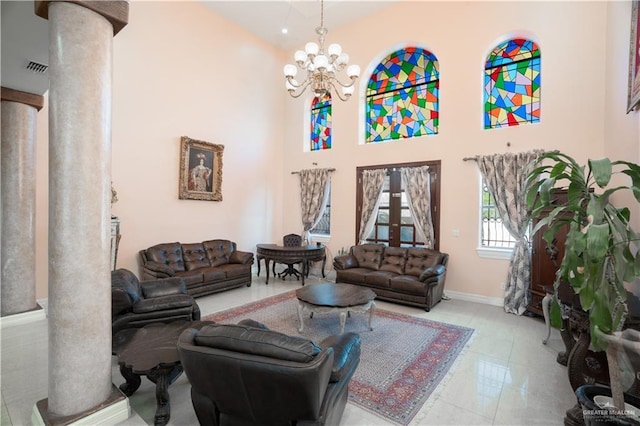 living area featuring decorative columns, an inviting chandelier, a towering ceiling, visible vents, and baseboards