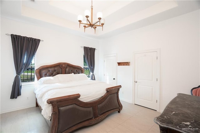 bedroom with a notable chandelier, a tray ceiling, and baseboards