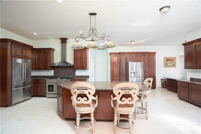 kitchen featuring high quality appliances, wall chimney range hood, recessed lighting, a center island, and backsplash